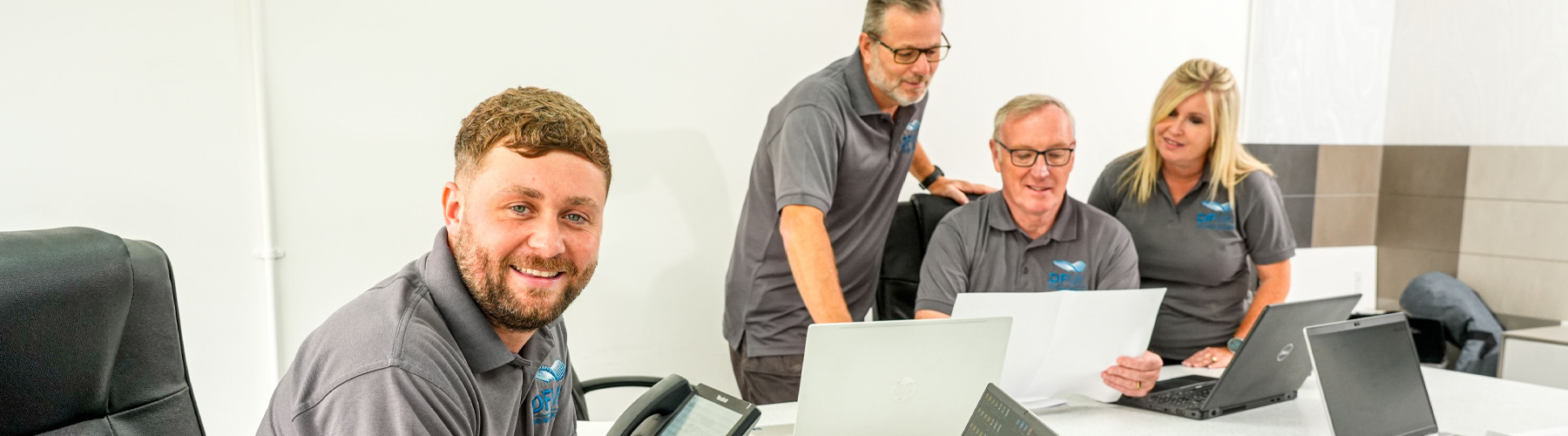 DFMK Team working around a desk with laptops